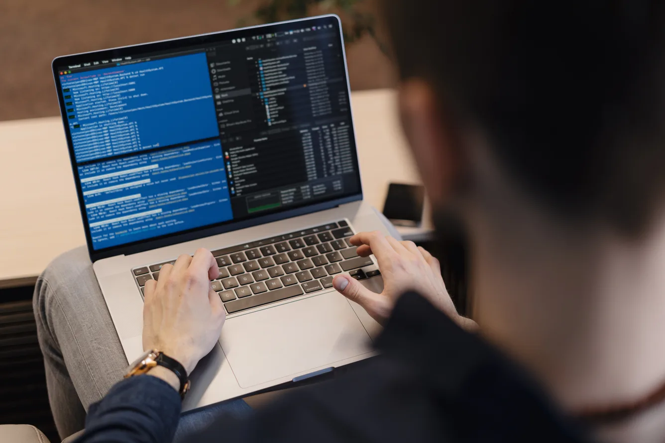 QA engineer reviewing automated software test results on a laptop